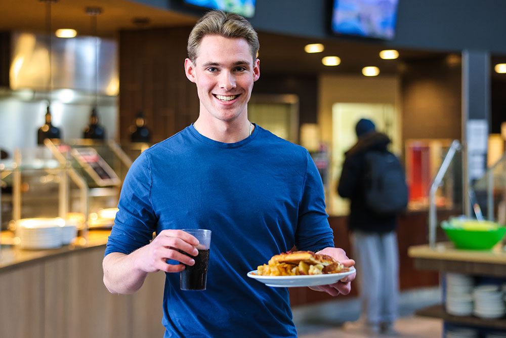 Student holding lunch from the Elements Dining Cafeteria