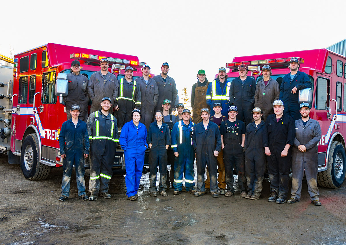 School of Trades students in front of the vehicles they serviced