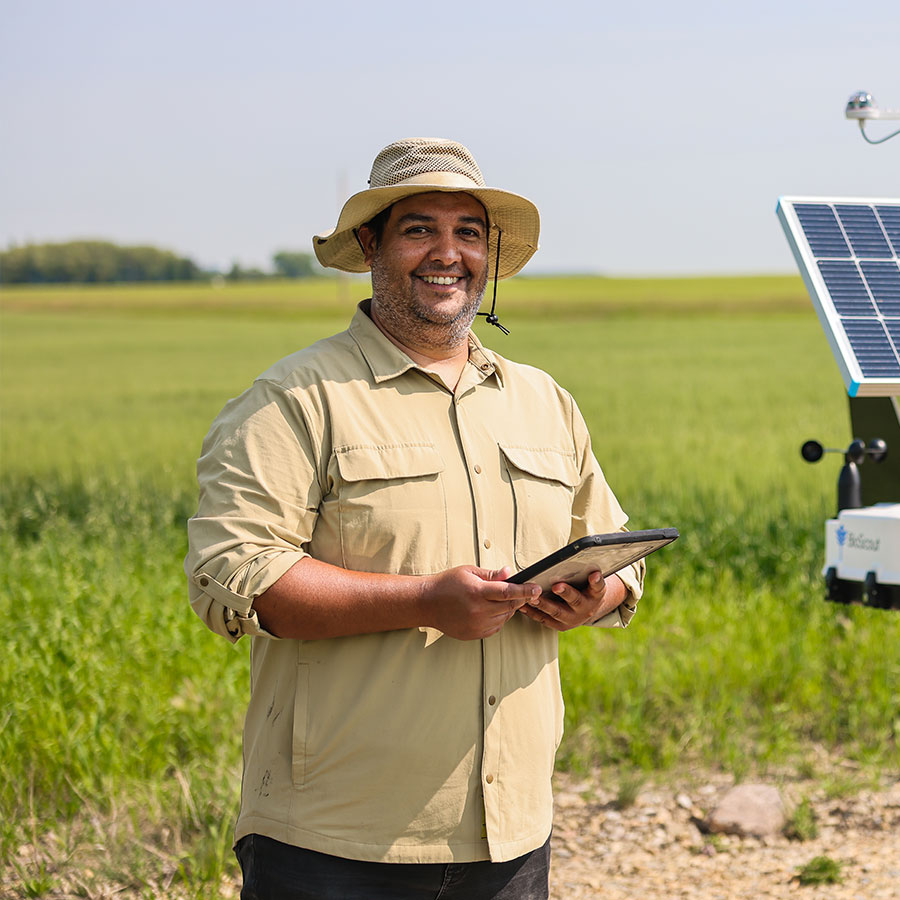 Juan Ramos standing on the Olds College smart farm in front of a sensor