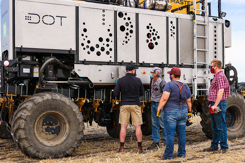 autonomous farm vehicle in field with Olds students