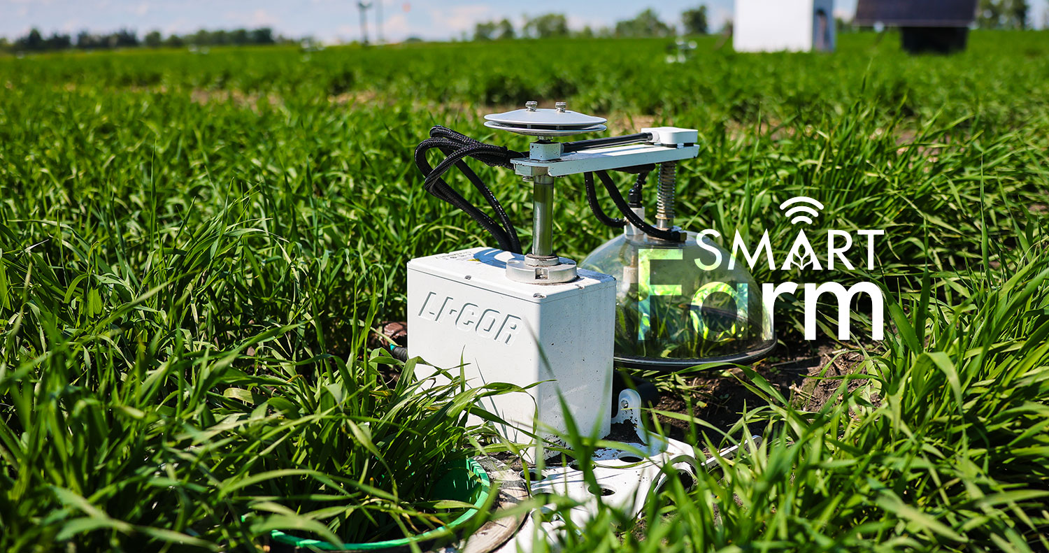 The purple & silver OmniPower sprayer driving through a green field.