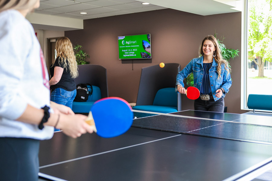 two female students playing table tennis