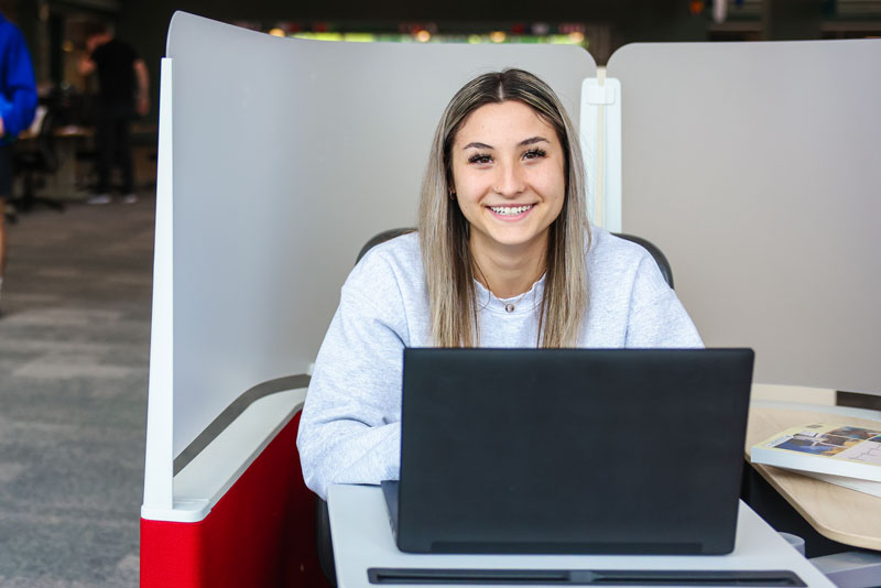 Student with a laptop in the learning commons