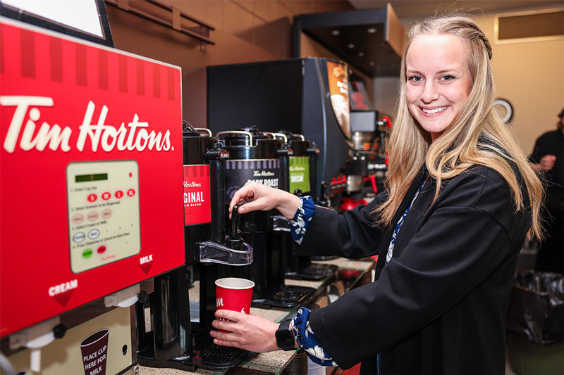Student filling up a coffee at the Tim Hortons Express